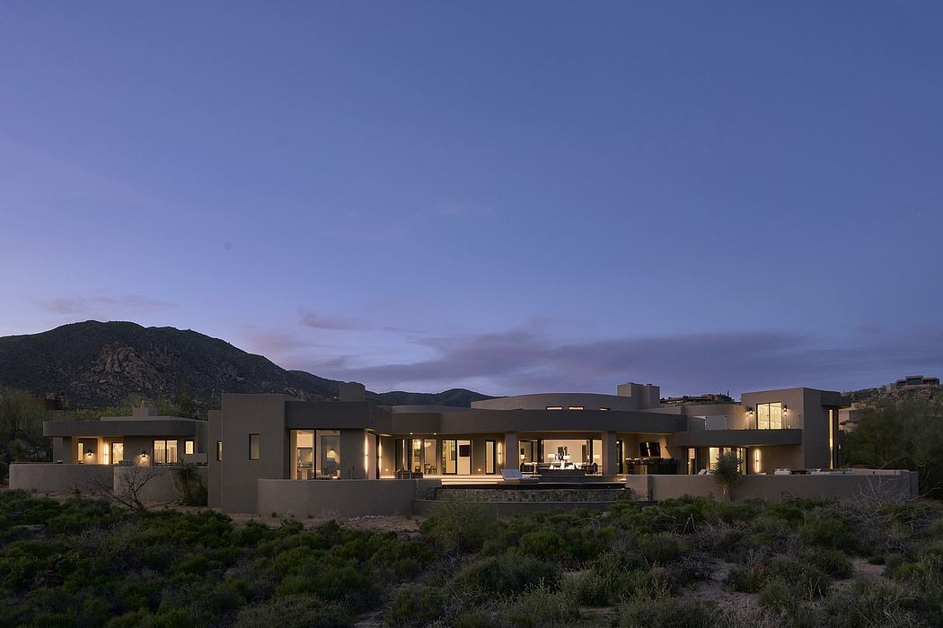 A modern desert retreat with clean lines, large windows, and a surrounding landscape.