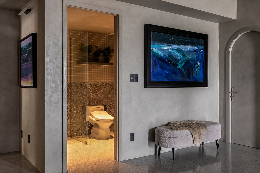 A modern, minimalist bathroom with a striking abstract painting and plush seating.