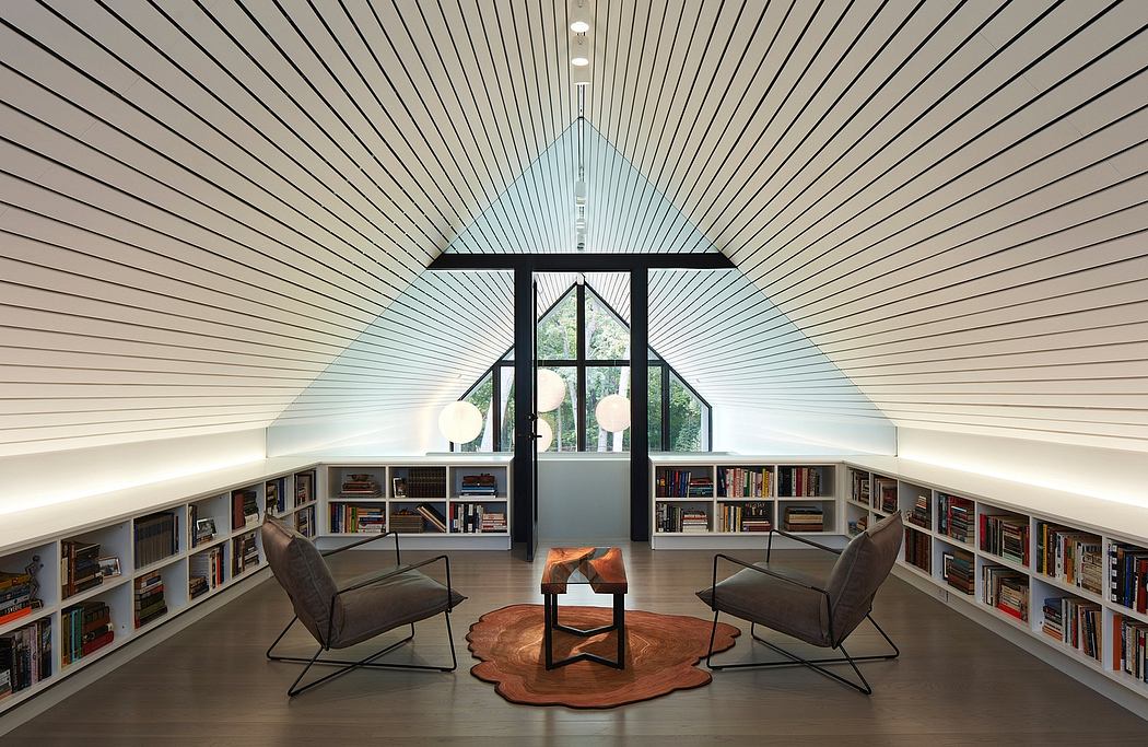 Modern reading nook with bookshelves, armchairs, fireplace, and