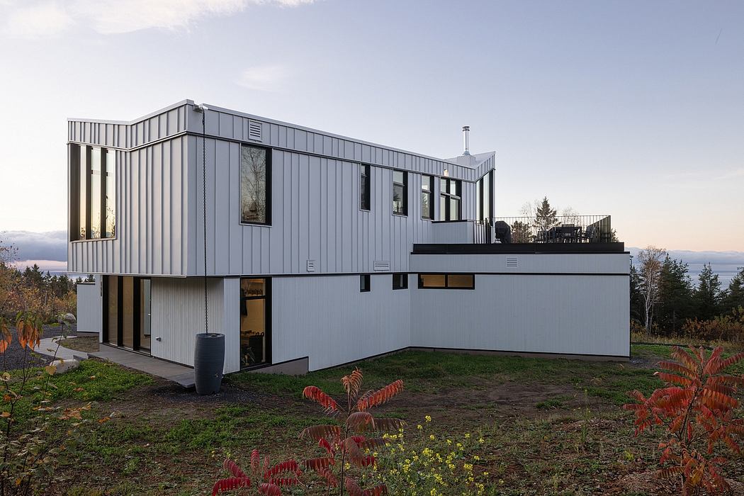 Contemporary two-story house with large windows and metal cladding.