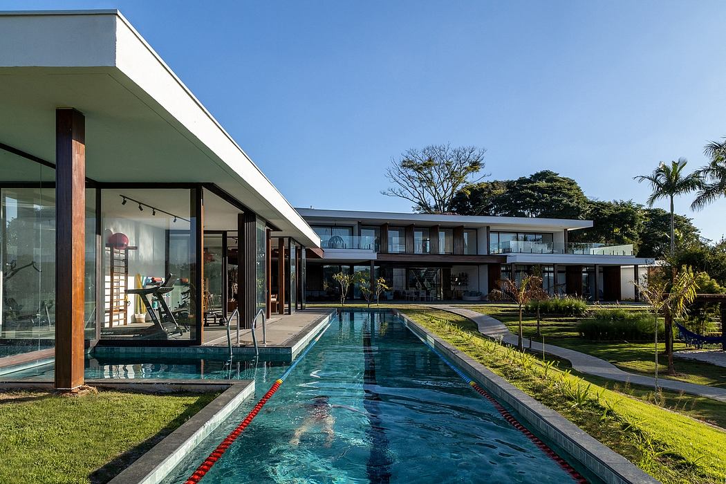 Sleek villa with pool, expansive glass walls, and flat roofs.
