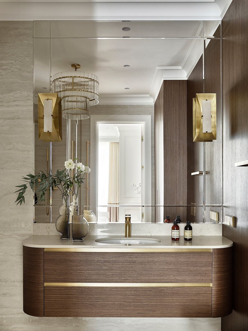 Elegant bathroom with modern lighting fixtures, marble countertop, and wood cabinetry.