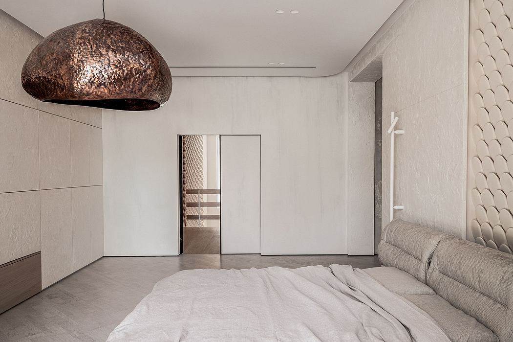 A modern bedroom interior with a large, metallic dome light fixture and sleek furnishings.