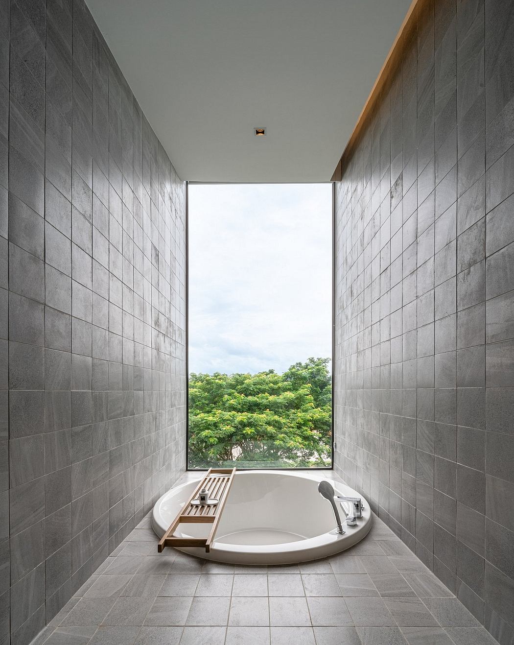 Minimalist bathroom with floor-to-ceiling window and freestanding tub.