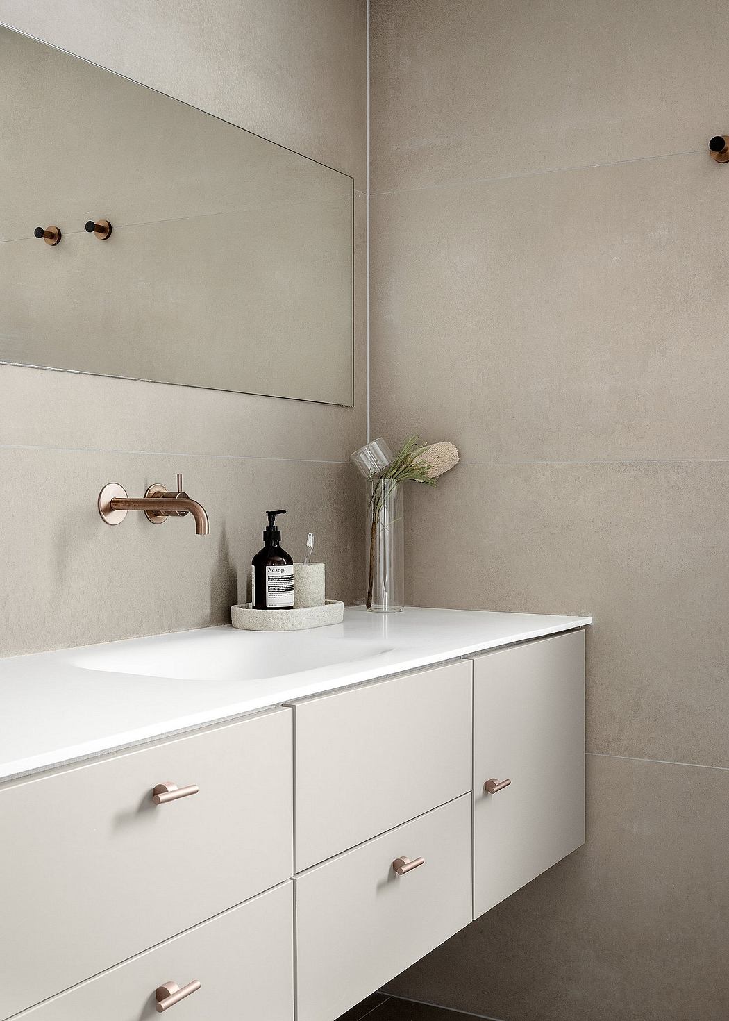 Minimalist bathroom with white vanity and rose gold fixtures.