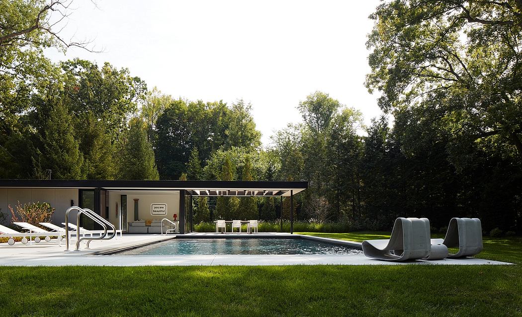 Modern backyard with pool, lounge chairs, and a pavilion surrounded by trees.