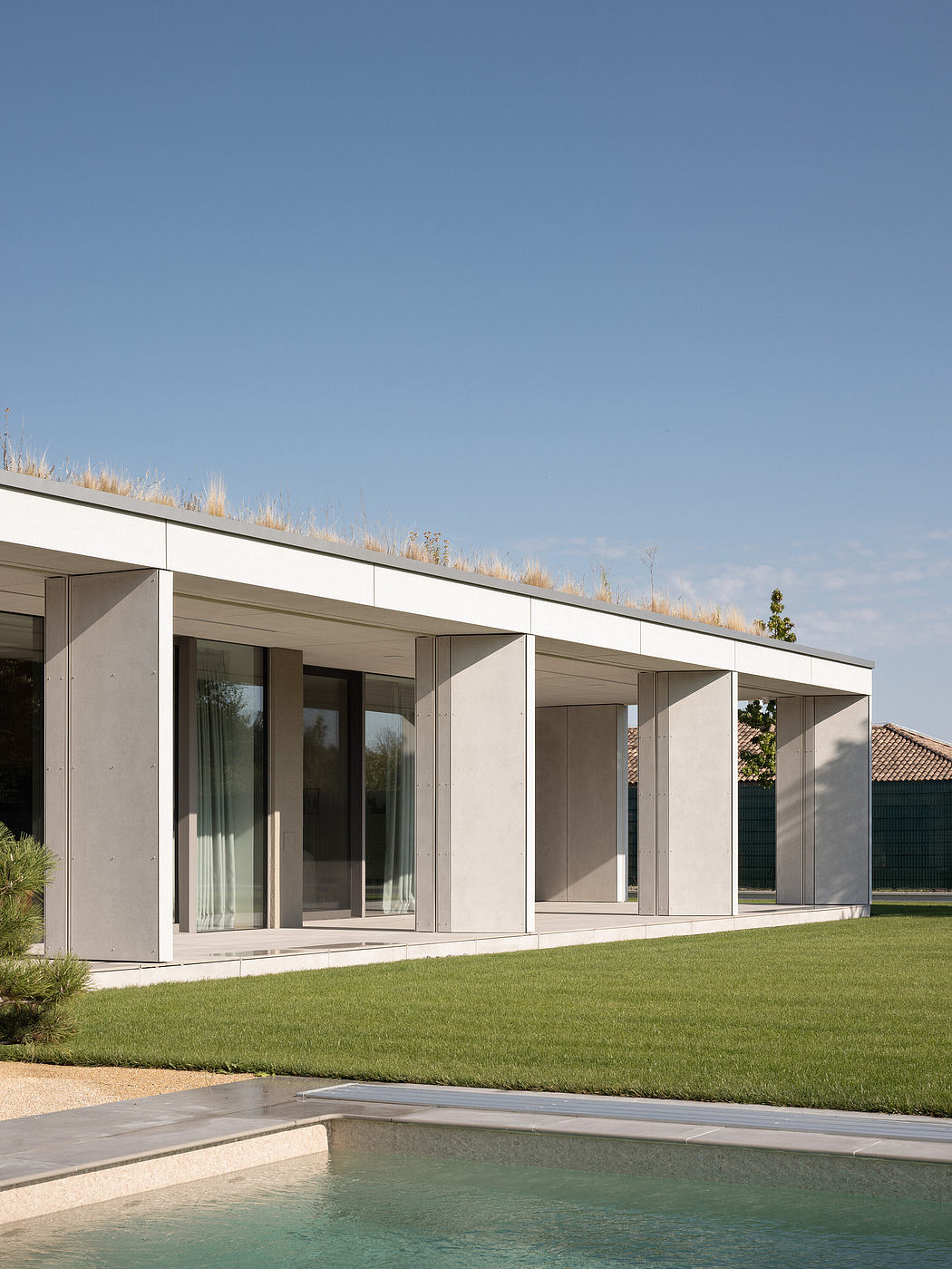 Modern house with large windows, flat roof, and pool.