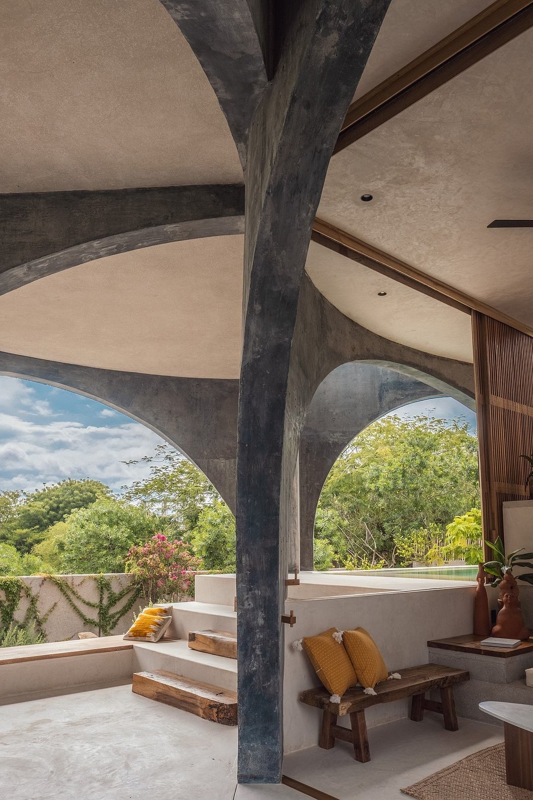 Striking concrete arches frame lush outdoor views, creating a serene, modern ambiance.
