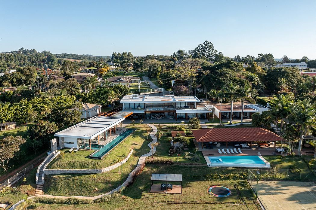 Aerial view of a modern residential complex with pool and landscaped gardens.