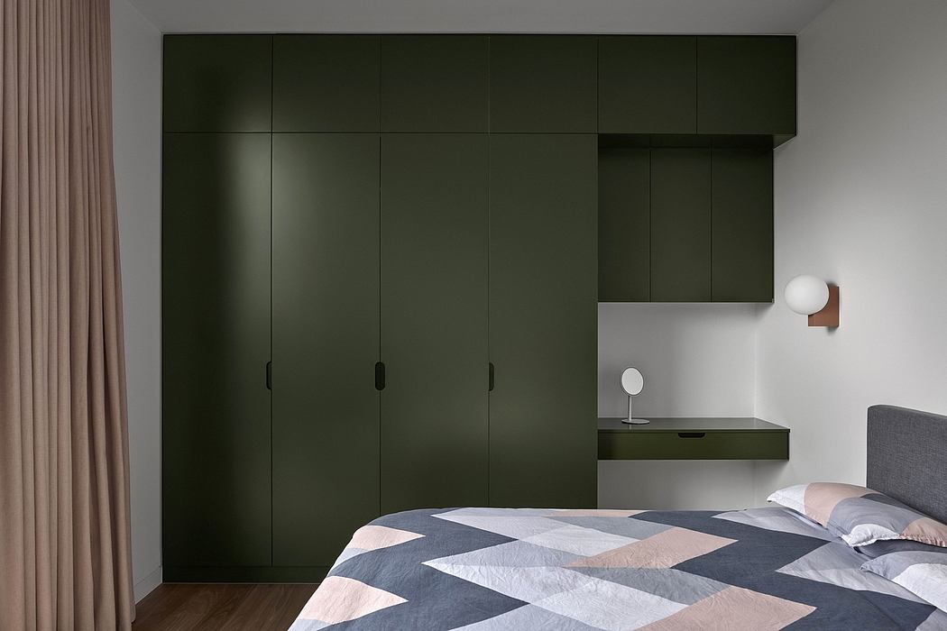 Minimalist bedroom with floor-to-ceiling dark green wardrobe, floating shelves, and geometric bedding.