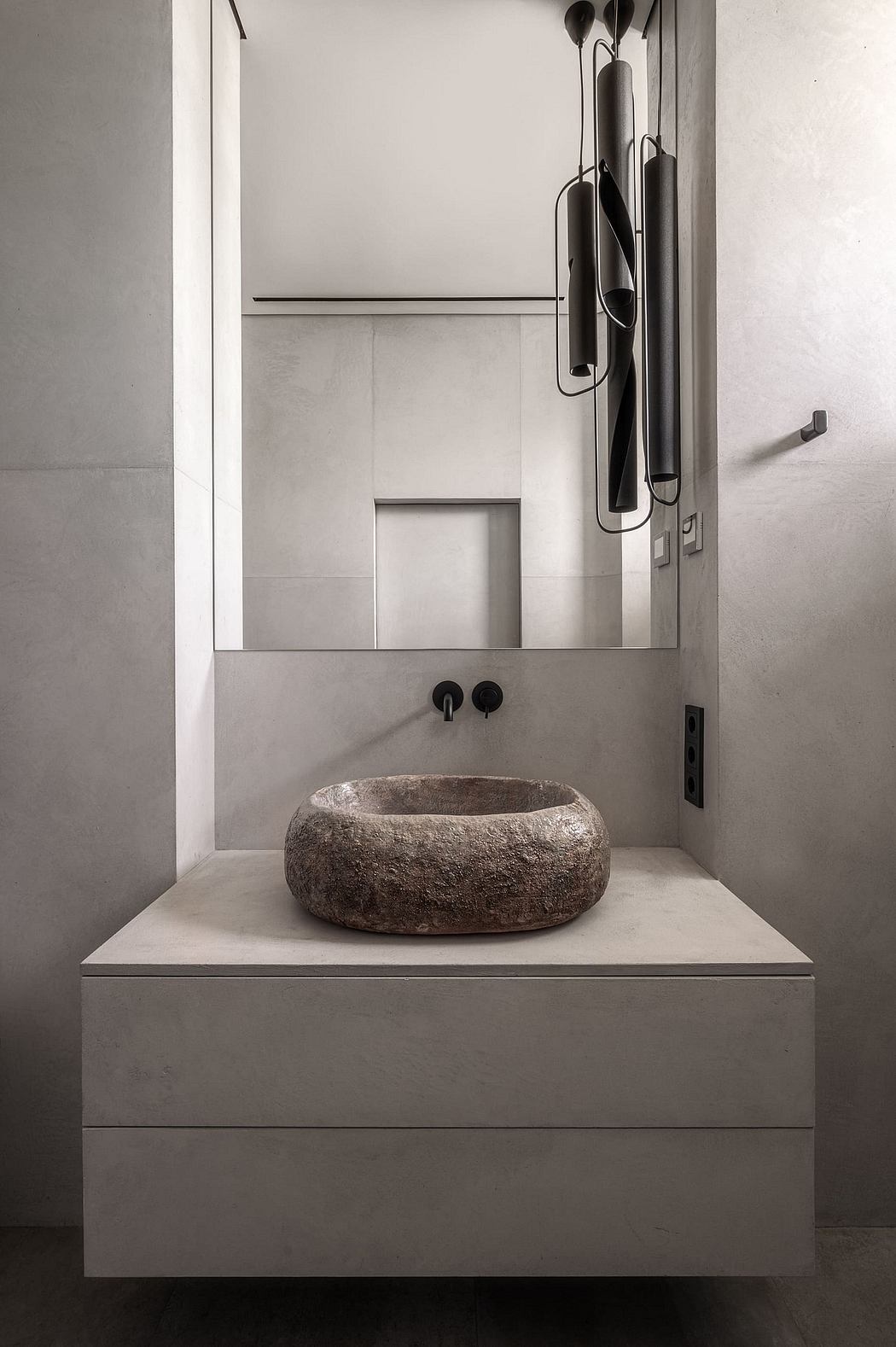 Contemporary bathroom vanity with a natural stone vessel sink, clean lines, and minimalist lighting.
