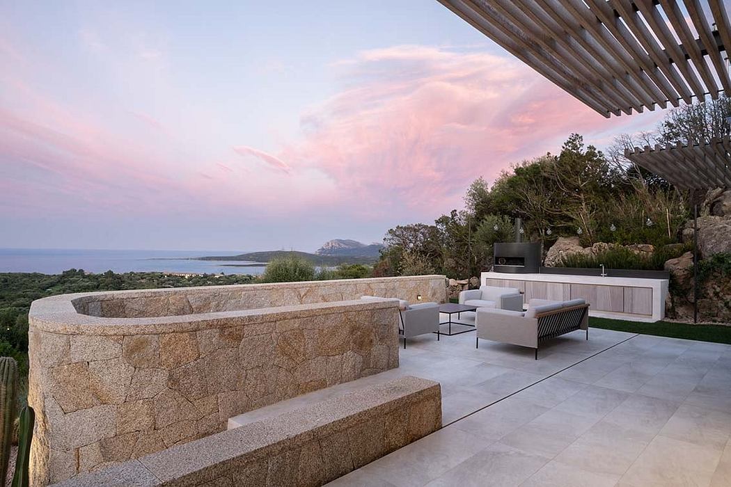Modern terrace with seating and sea view at sunset.
