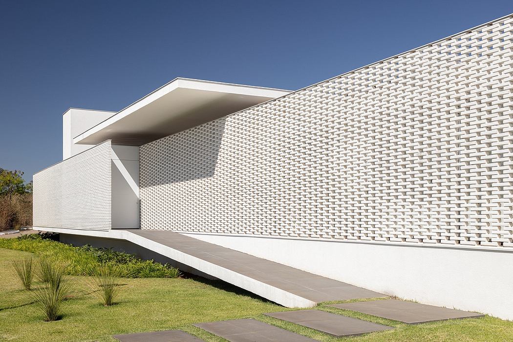Modern, geometric exterior with textured white facade and contrasting concrete elements.