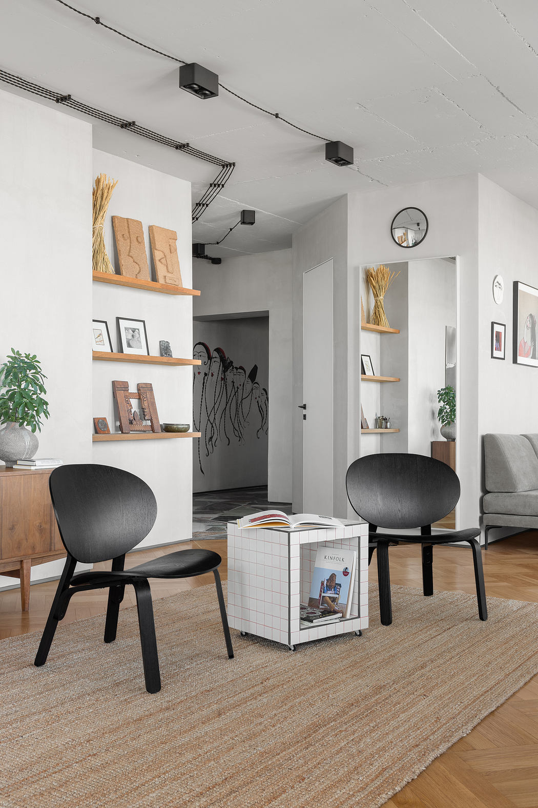 Modern and minimalist living room with sleek shelving, stylish chairs, and warm wood accents.