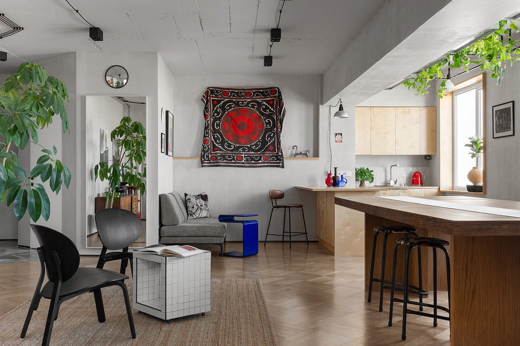 An open-concept living space with a mix of modern and rustic elements, including a decorative tapestry and lush greenery.