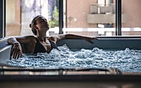 A young woman is relaxing in a jacuzzi.