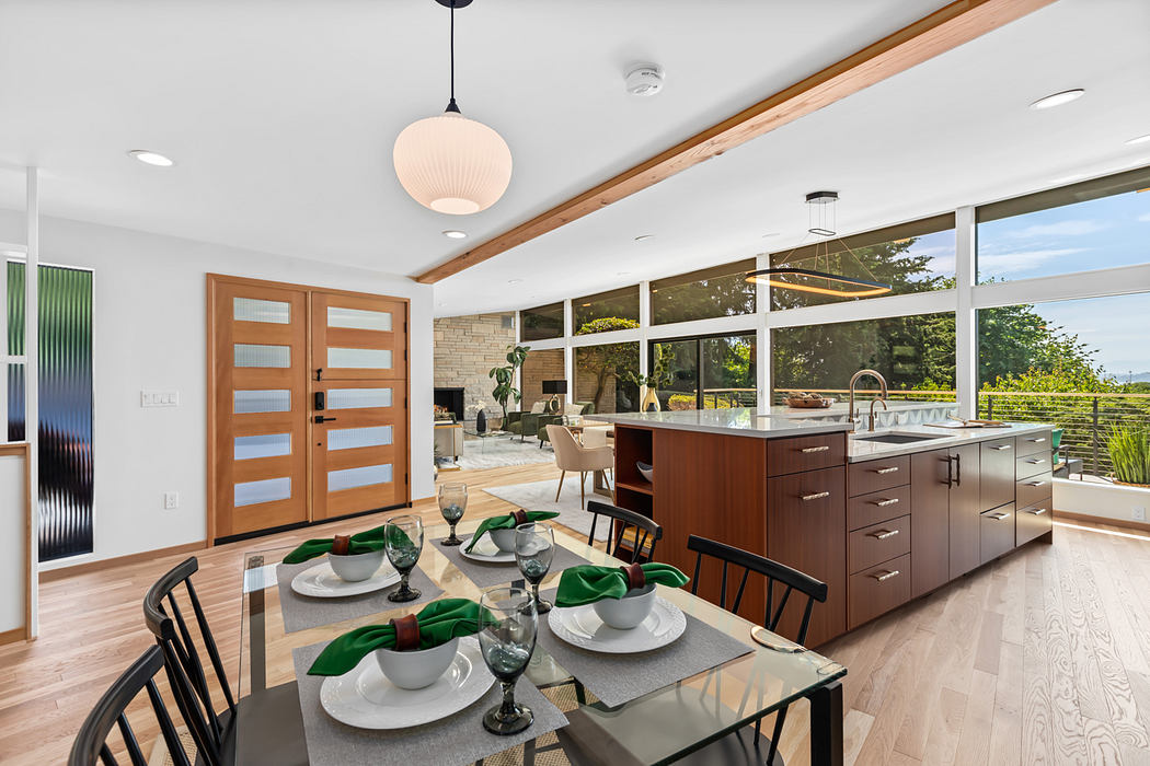 Spacious, modern kitchen with wood beams, large windows, and an open dining area.