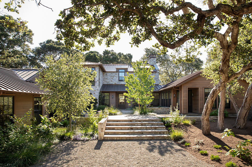 A rustic stone and wood home with a covered porch, surrounded by lush greenery.