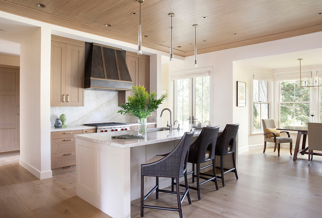 Spacious kitchen with neutral-toned cabinetry, marble countertops, and pendant lighting.