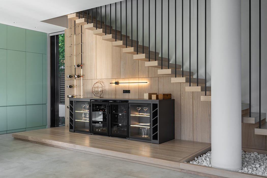 Striking modern staircase with linear metal railing and integrated wine storage cabinet.