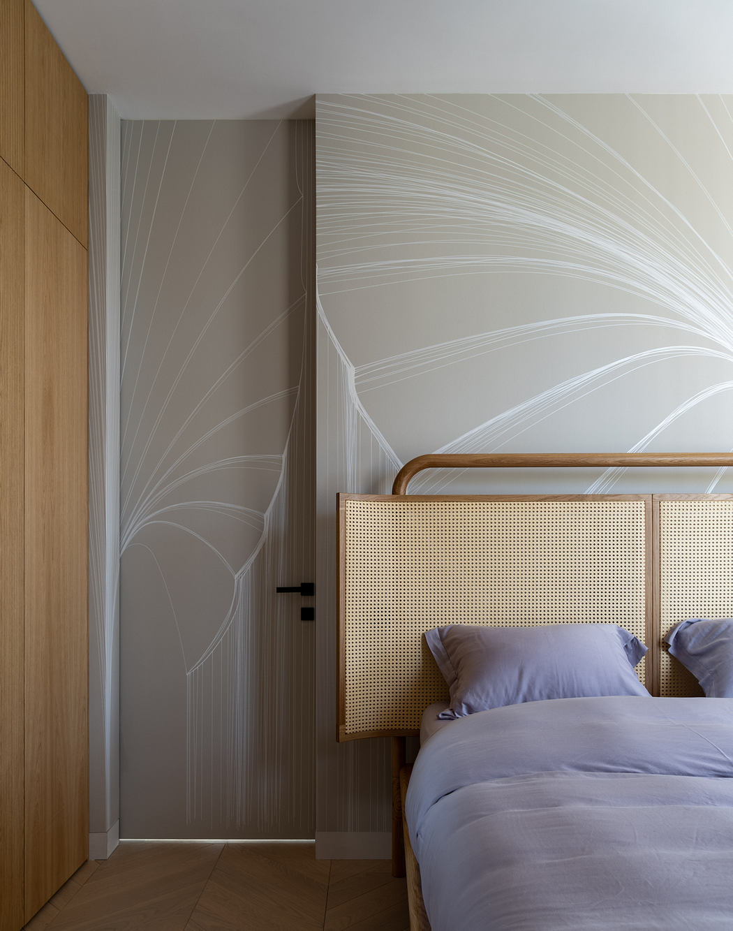 Minimalist bedroom design features wood paneling, textured wall, and woven headboard.