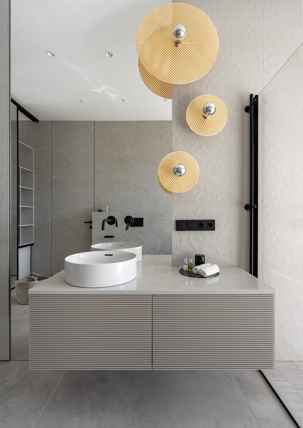 Modern bathroom with sleek vanity, circular mirrors, and minimalist decor.