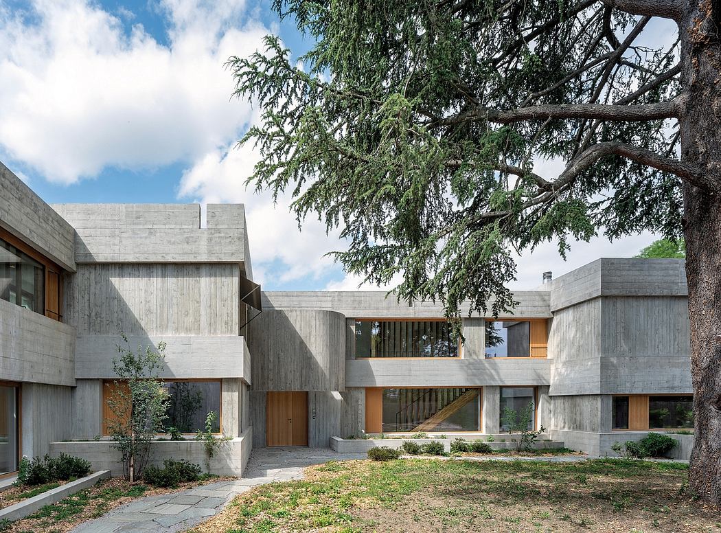 A modernist concrete residential complex with wood accents and lush surrounding greenery.