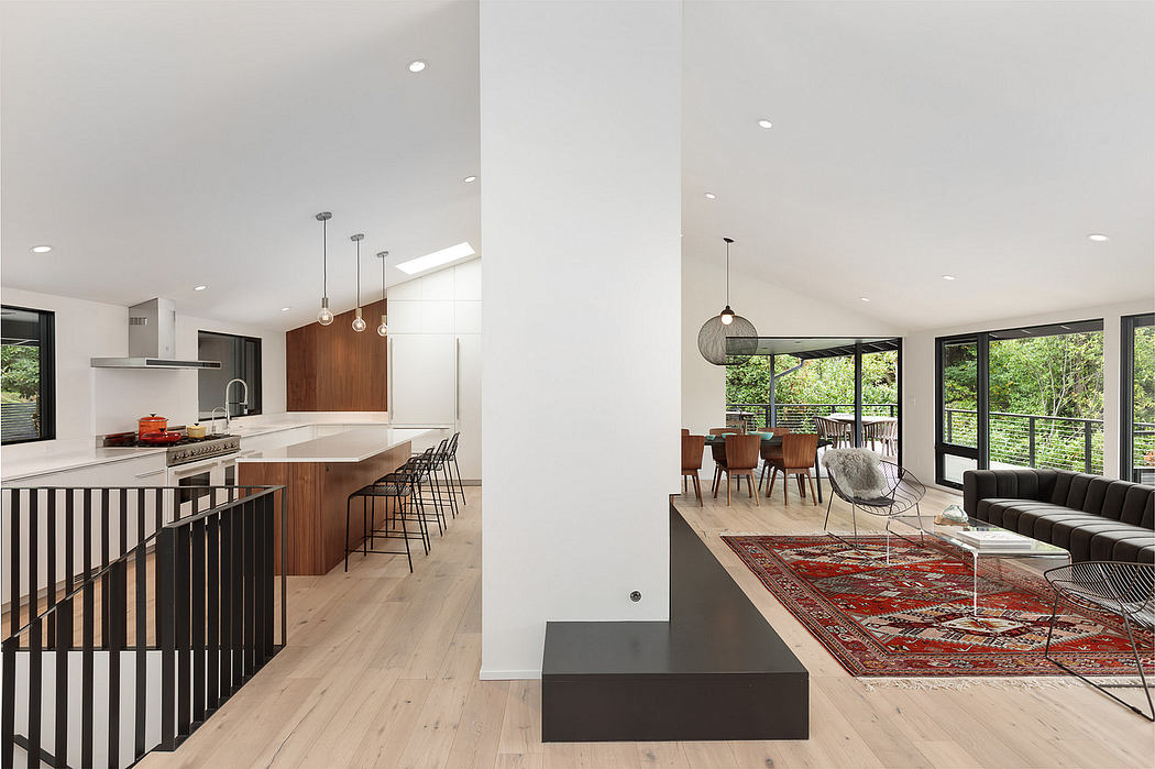 Modern open-concept kitchen and living room with wood accents, large windows, and statement lighting.