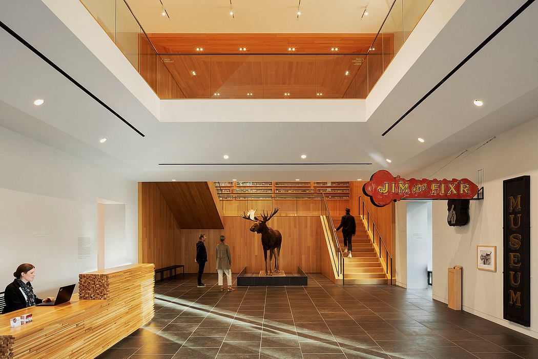 A grand, wood-paneled lobby with a towering moose statue, modern lighting, and a reception desk.