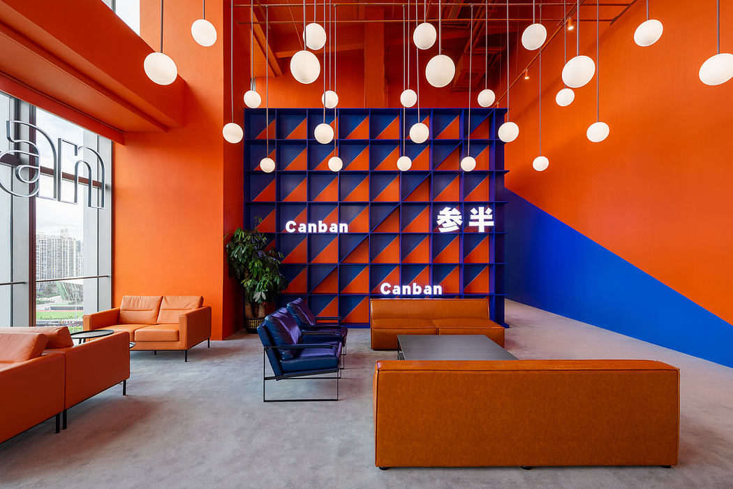 Vibrant orange and blue color scheme with suspended globe lights and modular furniture.