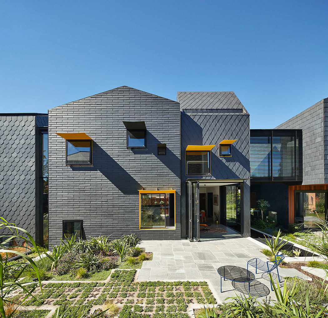 Striking modern architecture with geometric forms, contrasting materials, and lush landscaping.