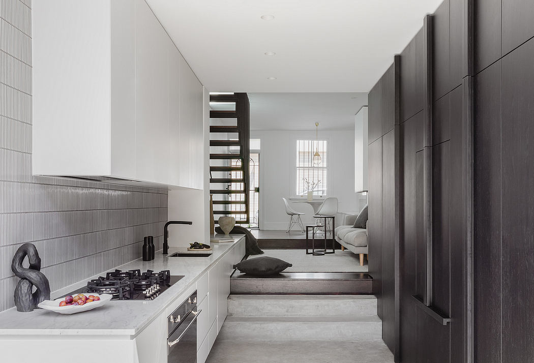A contemporary kitchen with sleek cabinetry, a gas stove, and an open living area beyond.