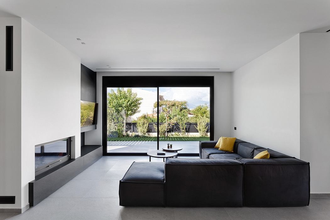 Sleek modern living room with large windows overlooking a lush outdoor garden.