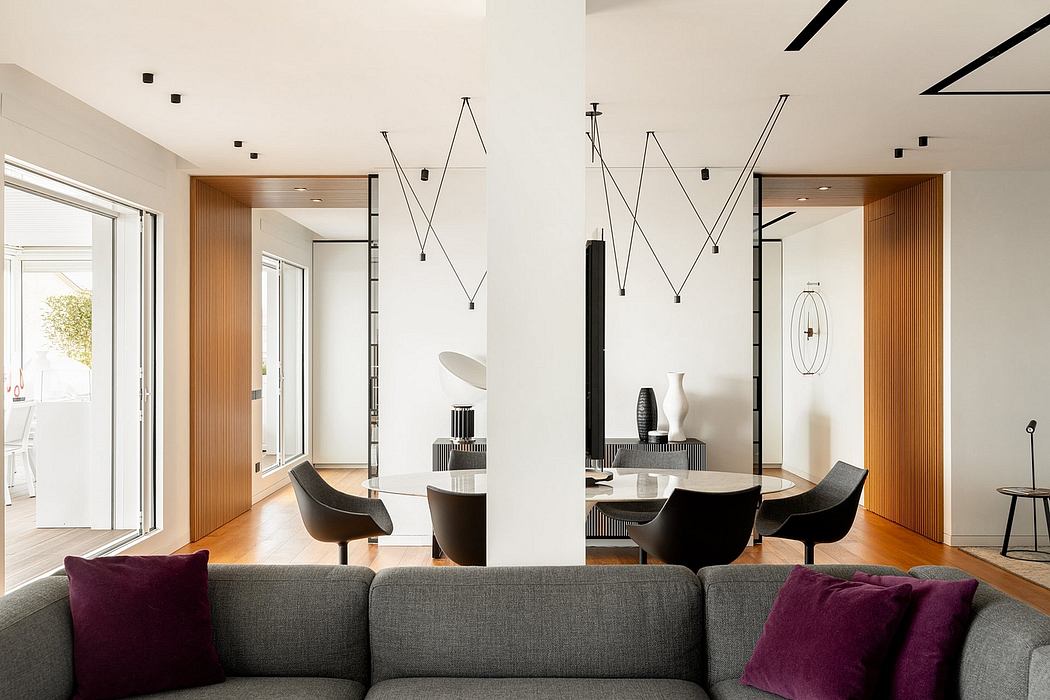 A modern, open-concept living space with sleek lighting fixtures, geometric patterns, and warm wood accents.