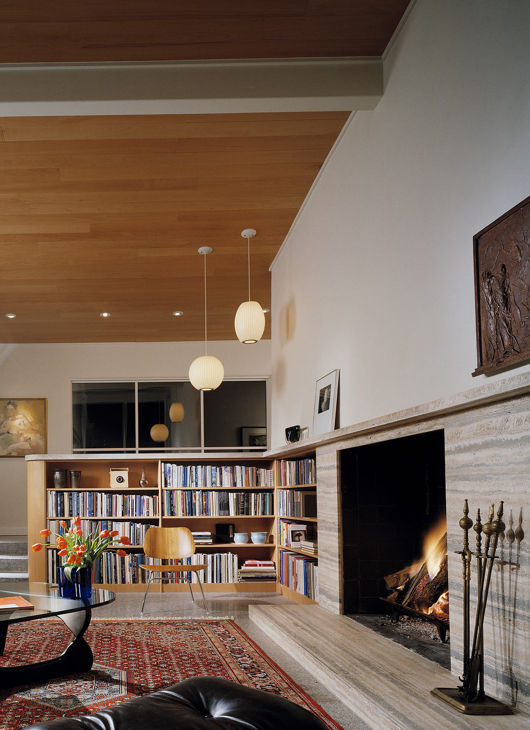Cozy living room with built-in bookshelves, fireplace, and pendant lighting.