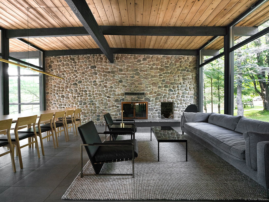 Rustic cabin interior with stone wall, wooden beams, and contemporary furnishings.