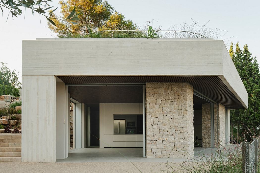 Minimalist concrete structure with stone facade and recessed entryway, showcasing modern design.