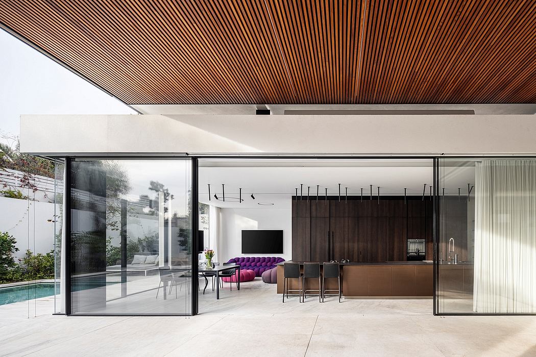 Modern interior with clean lines, wood-paneled ceiling, and sleek kitchen cabinetry.