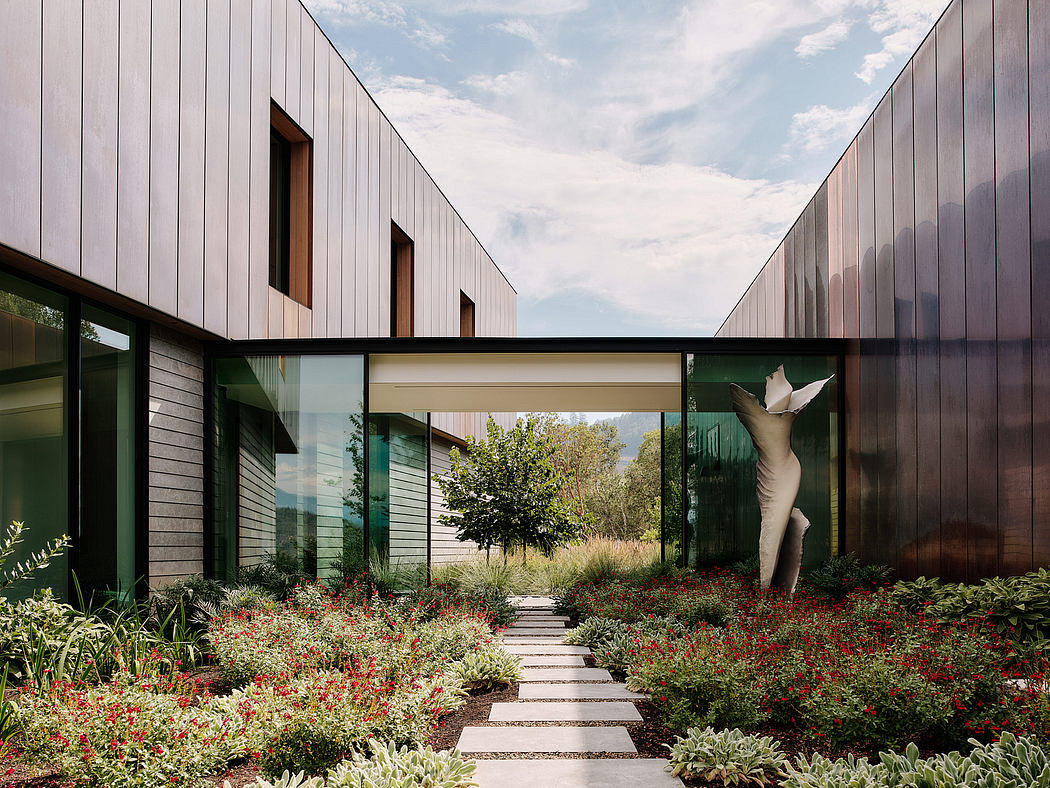 Striking modern architectural design with expansive glass walls and lush garden path.