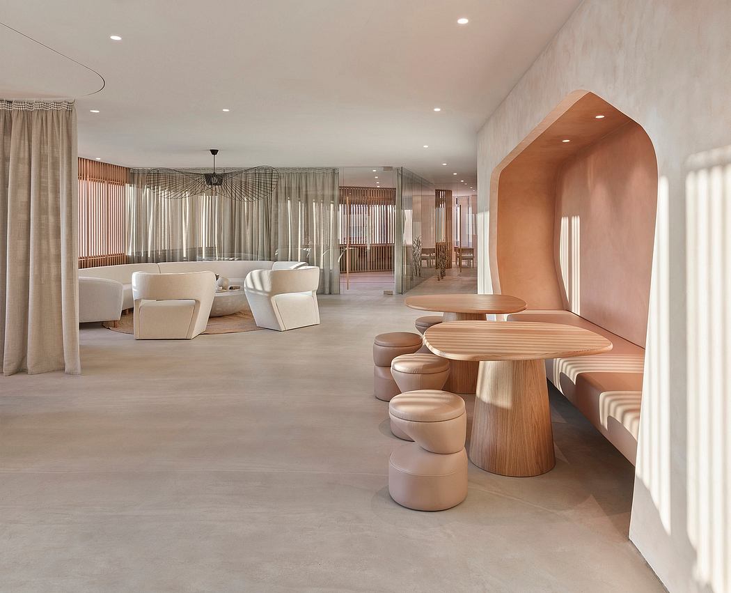 Spacious lounge with curved architectural forms, soft lighting, and minimalist furnishings.