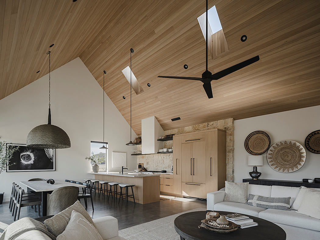 Spacious open-plan interior with wooden ceiling and beams, stone walls, and modern furnishings.