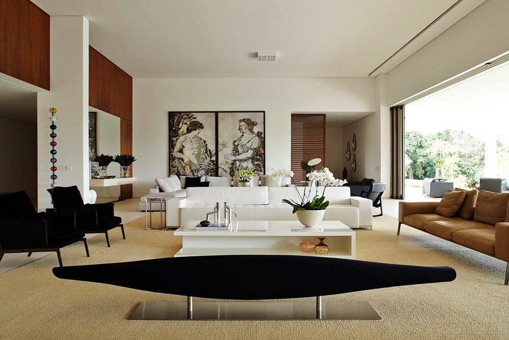 Spacious and elegant living room featuring modern furnishings, artwork, and large windows.