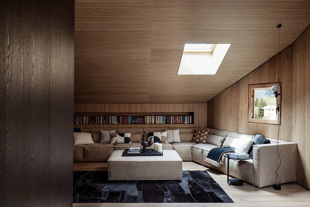 Wood-paneled living room with a large sectional sofa, built-in bookshelves, and a skylight.