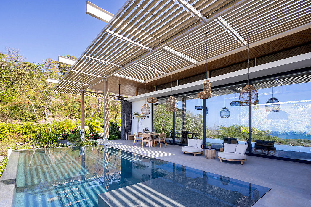 Modern outdoor living space with sleek architectural elements, a pool, and hanging light fixtures.