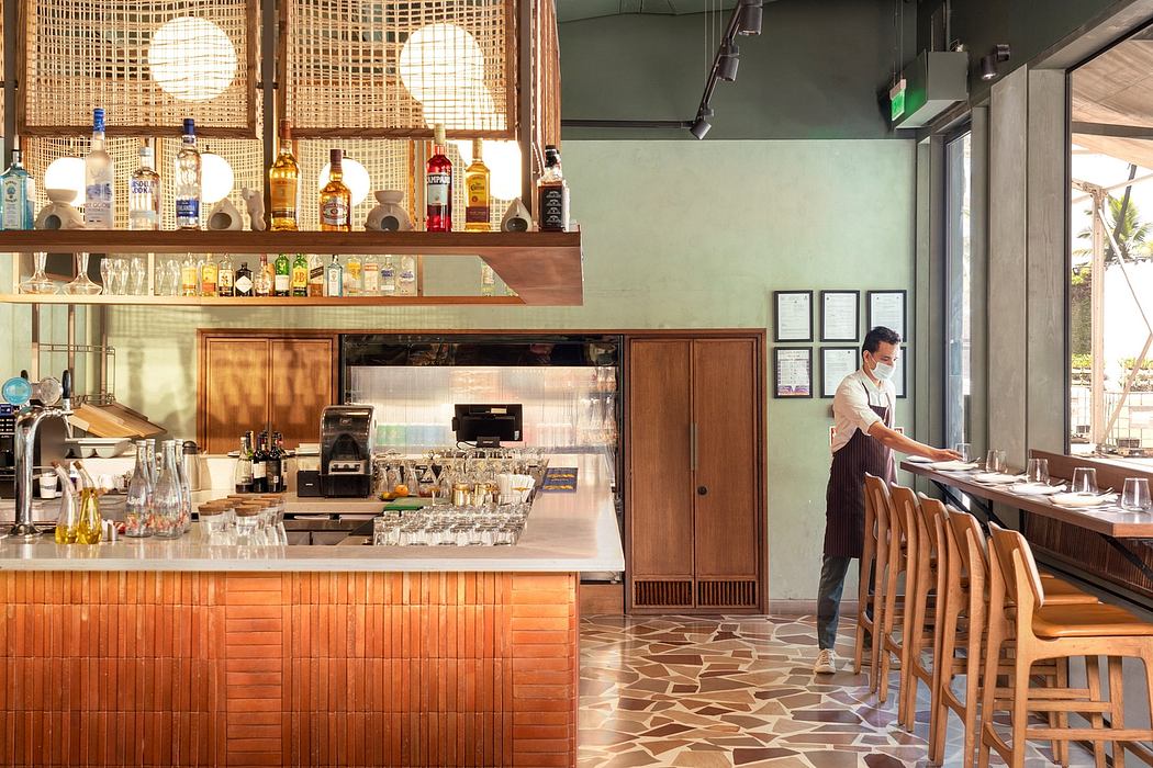 Warm-toned cafe interior with wooden accents, bar counter, and pendant lighting.