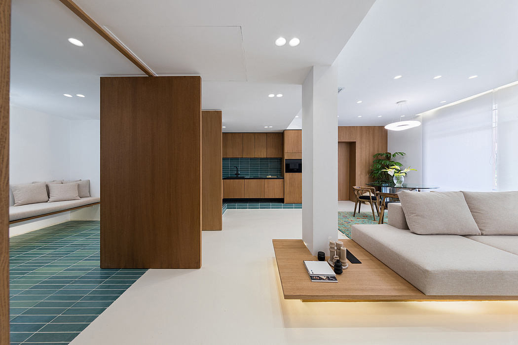Contemporary open-plan living space with wooden cabinetry, tiled flooring, and a comfortable sofa.