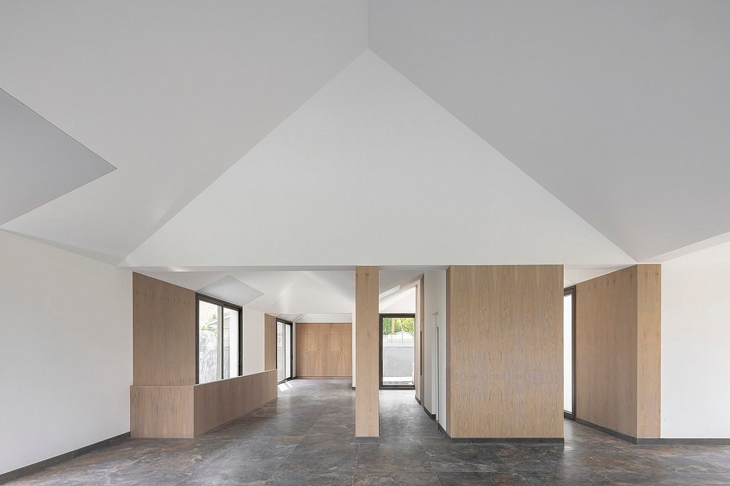 Spacious open-concept interior with high ceilings, wooden walls, and concrete flooring.