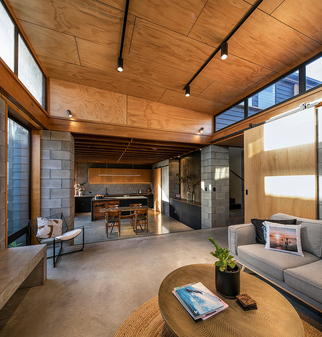 A cozy, modern living space featuring wood-paneled ceilings, sleek kitchen, and comfortable seating.