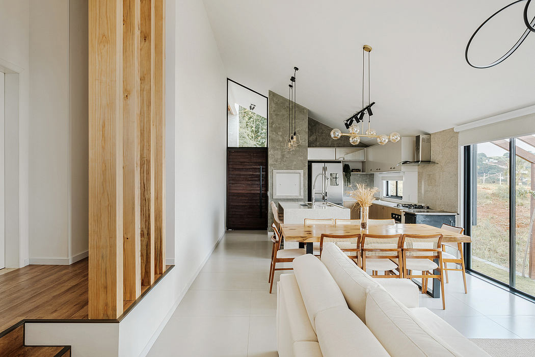 A modern, open-concept living space with minimalist furnishings, natural wood accents, and large windows.