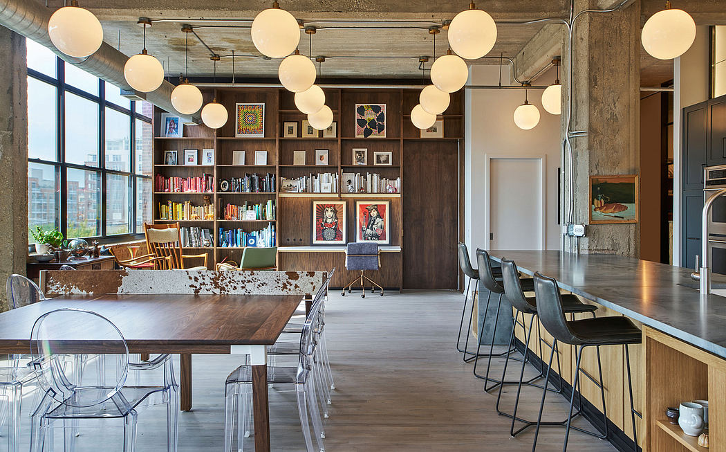 Rustic loft interior with exposed beams, bookshelves, and globe pendant lights.